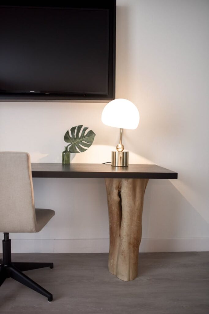 Elegantly designed modern workspace featuring a unique wood table, chair, and lamp.