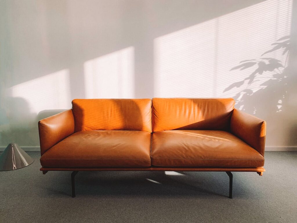 Stylish leather sofa with sunlit shadows in a contemporary home interior.